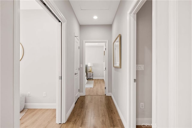 hall with recessed lighting, baseboards, and light wood finished floors