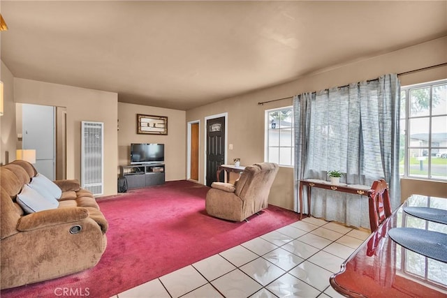 living area with tile patterned floors, plenty of natural light, and carpet