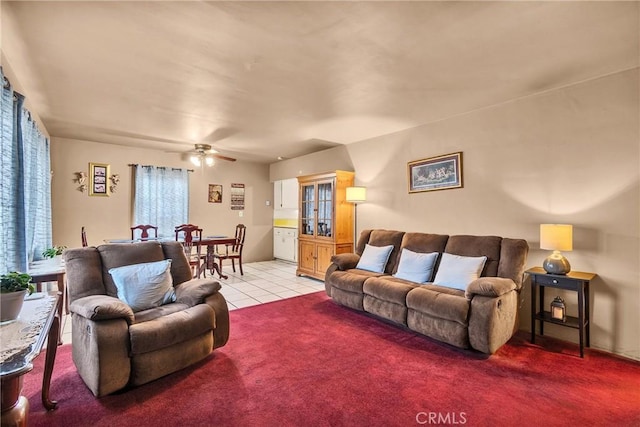 carpeted living room with tile patterned floors and a ceiling fan