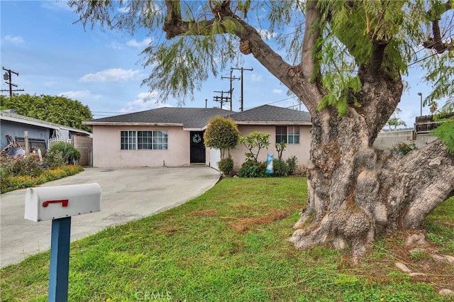 single story home with a front lawn, fence, and stucco siding