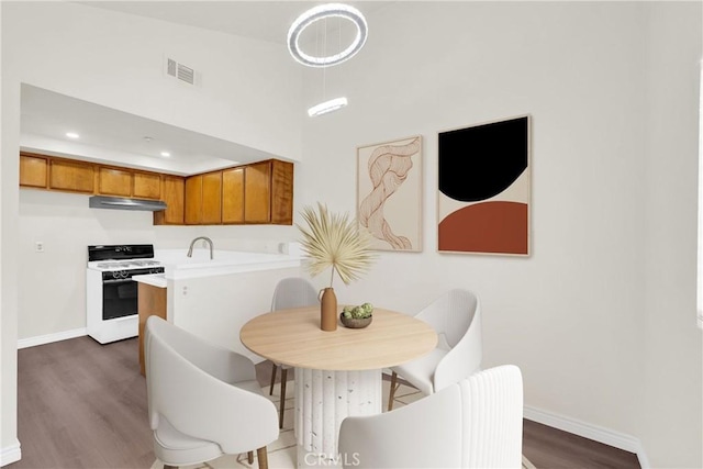 kitchen with white stove, visible vents, brown cabinets, and light countertops