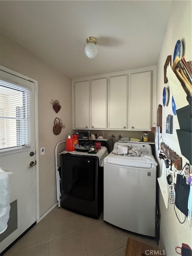 washroom featuring cabinet space, light tile patterned flooring, and washing machine and clothes dryer