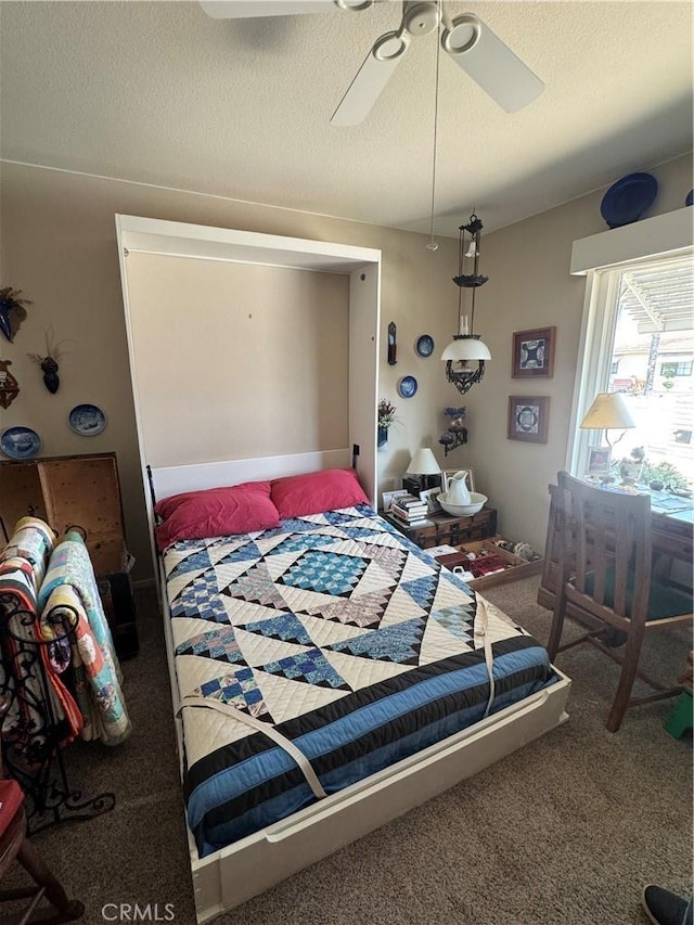 bedroom featuring carpet, a ceiling fan, and a textured ceiling