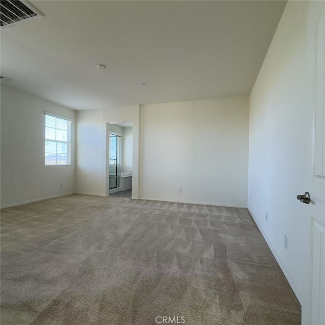 carpeted empty room featuring visible vents