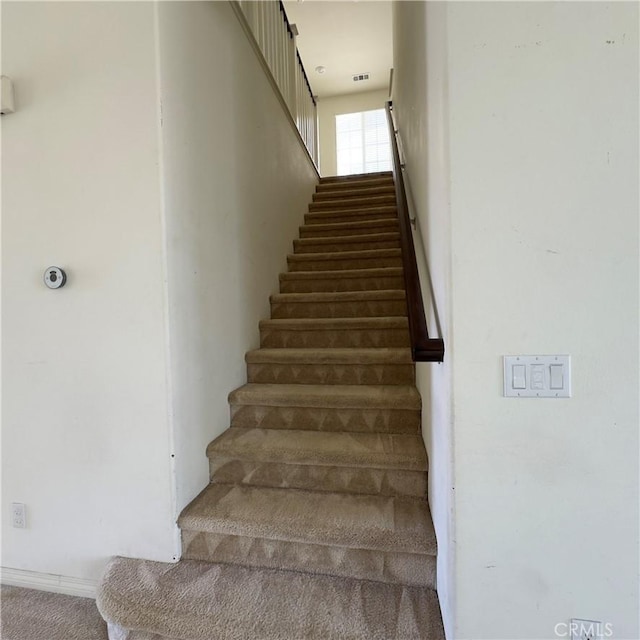 staircase with carpet flooring and visible vents