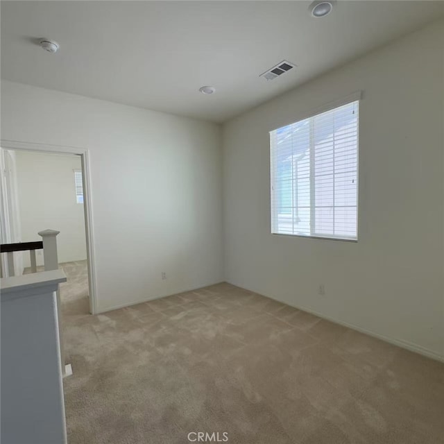 carpeted spare room featuring visible vents