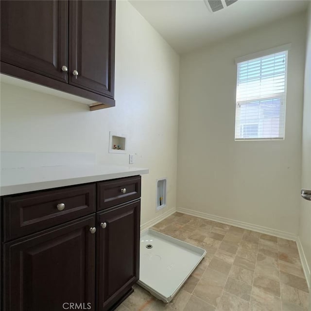 laundry area featuring hookup for a washing machine, cabinet space, and baseboards