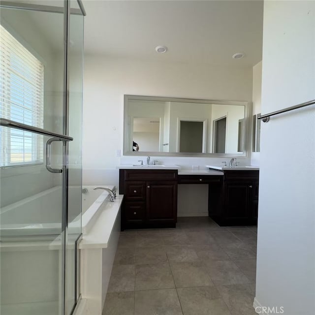 full bath with a sink, a bath, and double vanity