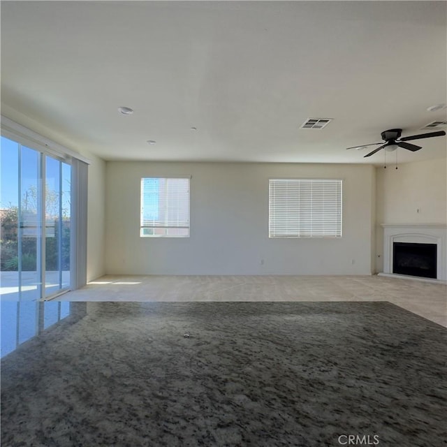 4435 S Zion Trl, Ontario, CA 91762 - unfurnished living room with a ceiling fan, visible vents, carpet floors, and a fireplace with raised hearth