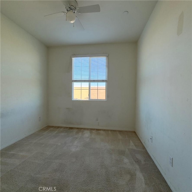 carpeted spare room with a ceiling fan