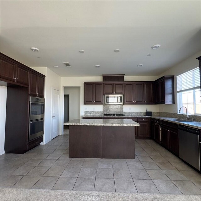 4435 S Zion Trl, Ontario, CA 91762 - kitchen featuring visible vents, a sink, a kitchen island, dark brown cabinetry, and appliances with stainless steel finishes