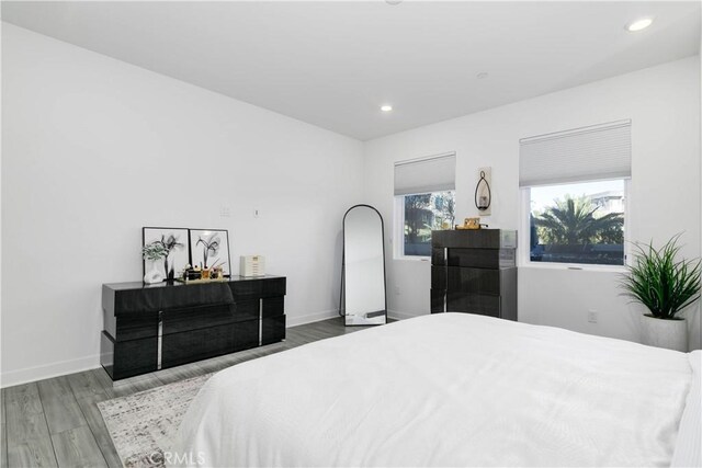 bedroom with recessed lighting, baseboards, and wood finished floors