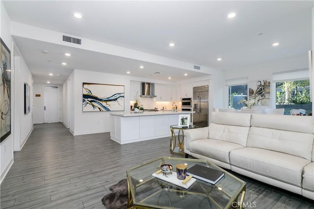 living area featuring recessed lighting, wood finished floors, visible vents, and baseboards