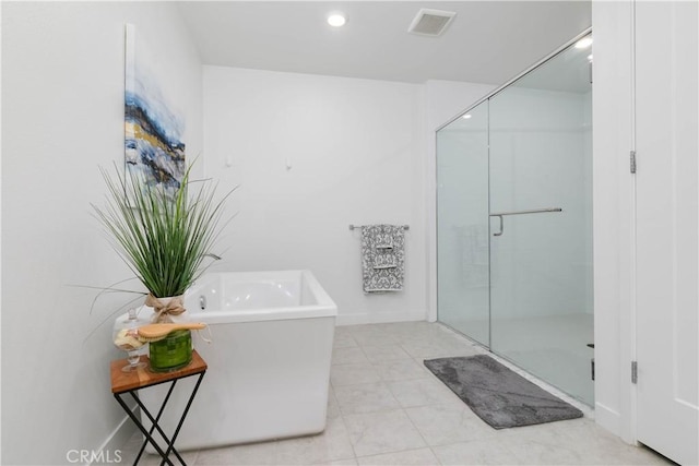 bathroom with tile patterned floors, visible vents, a shower stall, baseboards, and a soaking tub