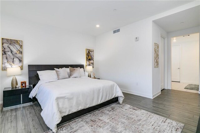 bedroom with visible vents, recessed lighting, baseboards, and wood finished floors