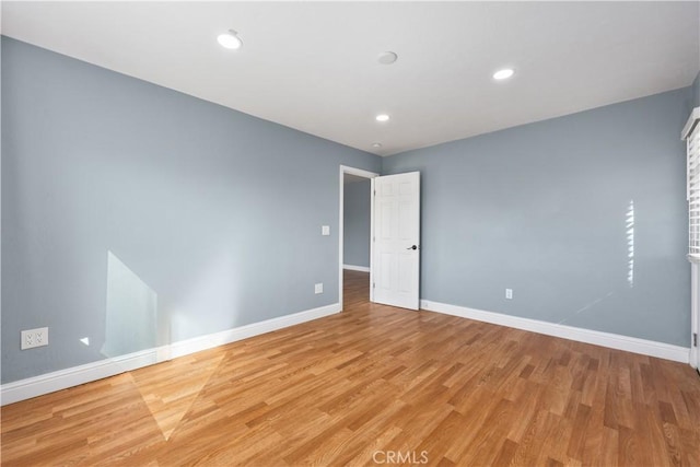 empty room featuring recessed lighting, light wood-style flooring, and baseboards