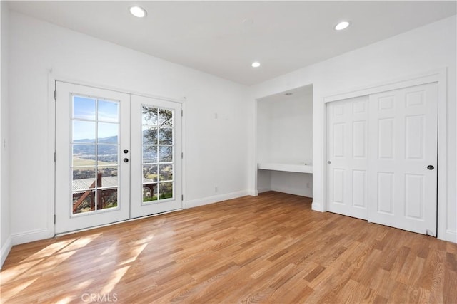 interior space with recessed lighting, french doors, baseboards, and light wood finished floors