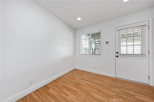 entryway with lofted ceiling, recessed lighting, light wood-style flooring, and baseboards