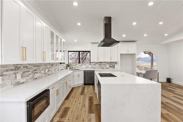 kitchen featuring backsplash, a kitchen island, a sink, black appliances, and extractor fan