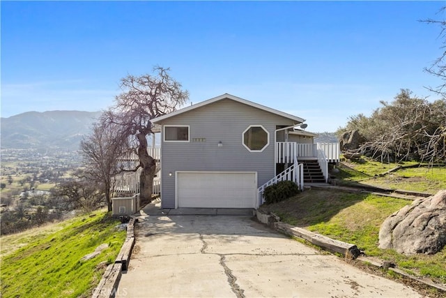 view of front of house featuring an attached garage, stairway, a mountain view, and concrete driveway