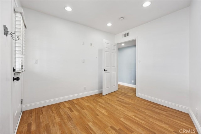 unfurnished room with light wood-style flooring, visible vents, baseboards, and recessed lighting