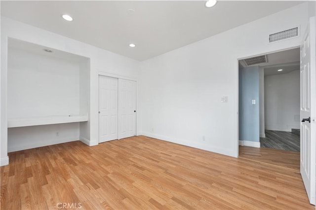 unfurnished bedroom featuring baseboards, light wood-type flooring, visible vents, and recessed lighting