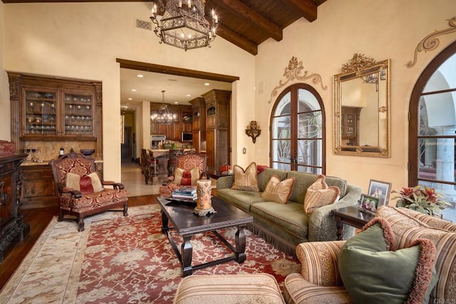 living room with high vaulted ceiling, a notable chandelier, wood finished floors, wood ceiling, and beamed ceiling