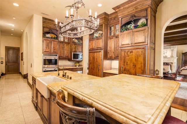 kitchen with a breakfast bar area, light tile patterned floors, recessed lighting, appliances with stainless steel finishes, and a sink