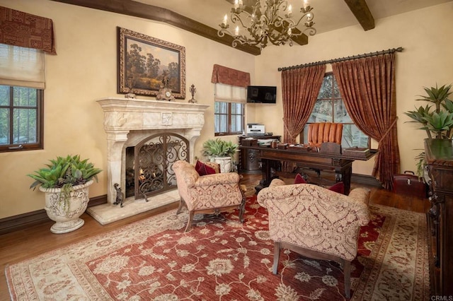 sitting room with beam ceiling, plenty of natural light, and wood finished floors