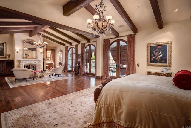 bedroom with french doors, a fireplace, hardwood / wood-style floors, and an inviting chandelier