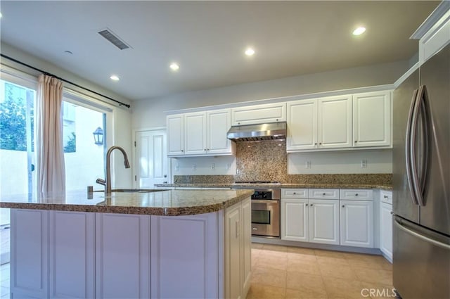 kitchen featuring visible vents, stainless steel appliances, under cabinet range hood, white cabinetry, and a sink