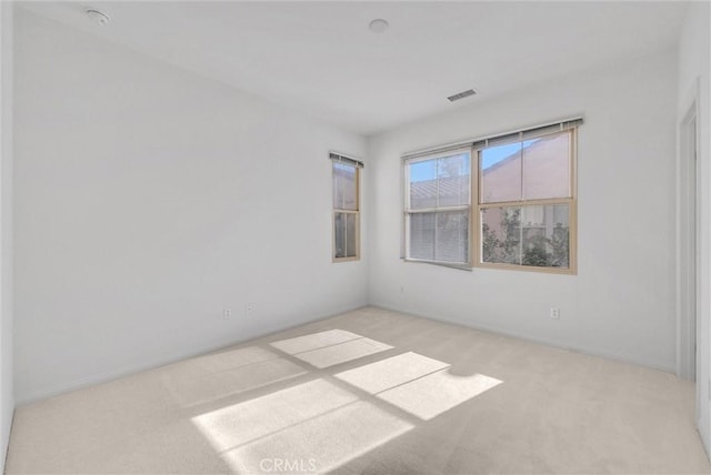 carpeted spare room featuring visible vents