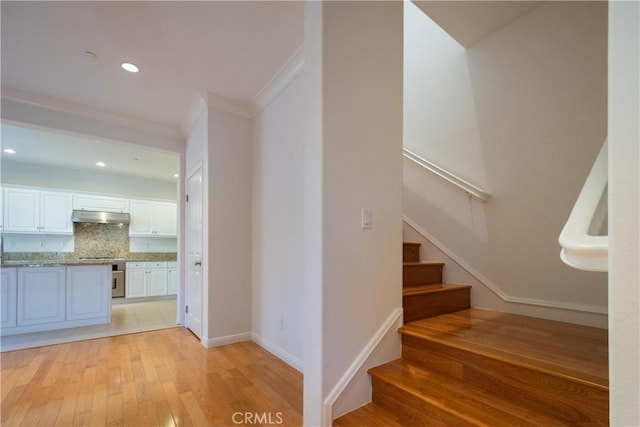 stairway with crown molding, hardwood / wood-style floors, recessed lighting, and baseboards