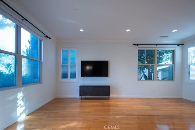 unfurnished living room with light wood-style floors, baseboards, crown molding, and recessed lighting