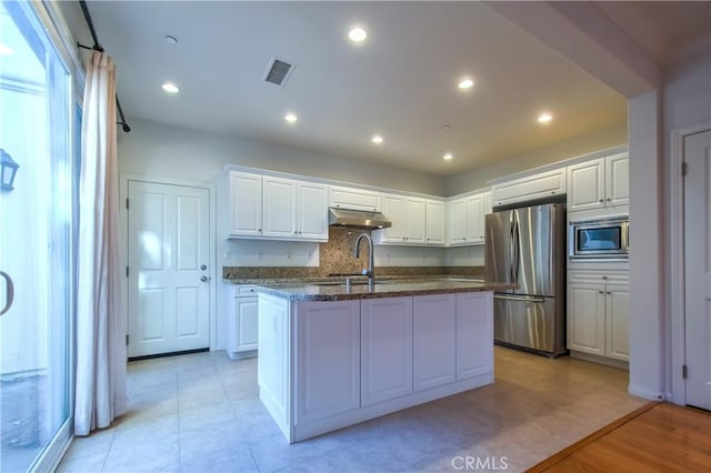 kitchen with white cabinets, appliances with stainless steel finishes, visible vents, and under cabinet range hood