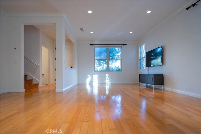 unfurnished living room with baseboards, light wood-style flooring, stairway, ornamental molding, and recessed lighting