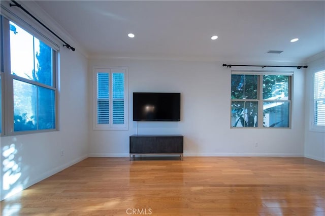 unfurnished living room with ornamental molding, recessed lighting, light wood-style flooring, and baseboards