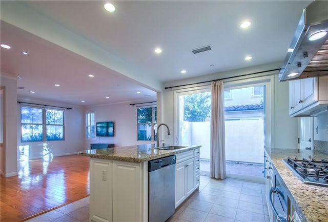 kitchen with a sink, visible vents, white cabinets, appliances with stainless steel finishes, and range hood