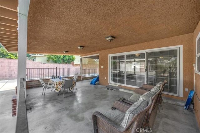 view of patio with fence and outdoor dining space