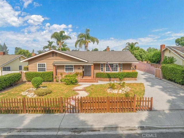 ranch-style house with driveway, a fenced front yard, and a chimney