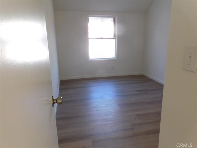 empty room featuring baseboards and wood finished floors