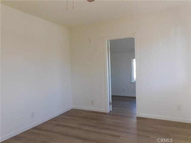 unfurnished room featuring baseboards and wood finished floors