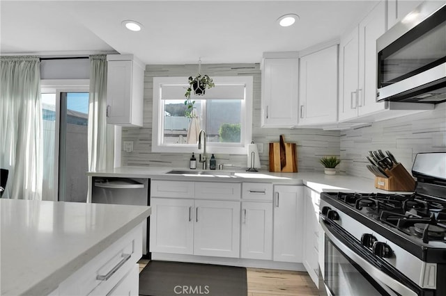 kitchen featuring a healthy amount of sunlight, appliances with stainless steel finishes, light countertops, and a sink