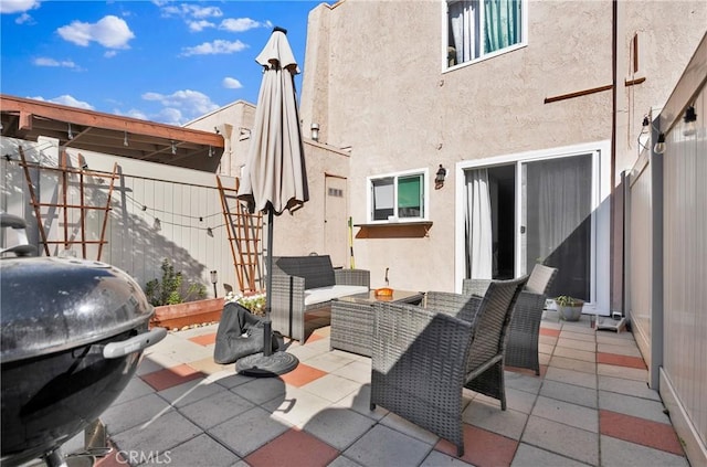 view of patio featuring grilling area, outdoor lounge area, and fence