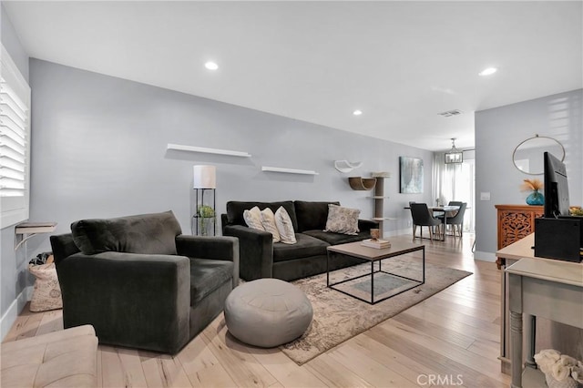 living room featuring recessed lighting, visible vents, light wood-type flooring, and baseboards