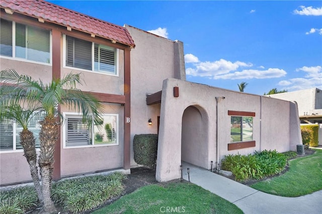 view of front of property with stucco siding and a tile roof