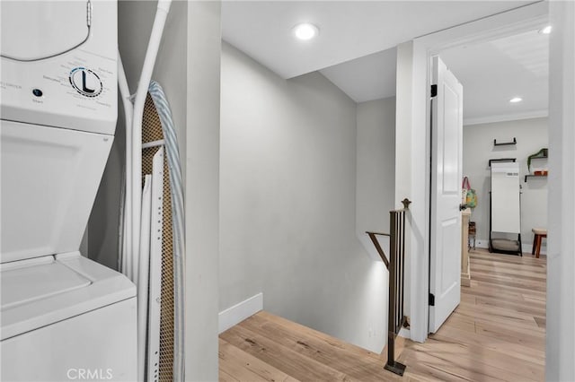 washroom featuring stacked washer / dryer, recessed lighting, laundry area, and light wood-style floors