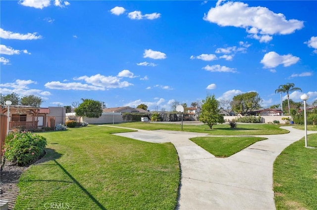 view of home's community featuring a lawn and fence