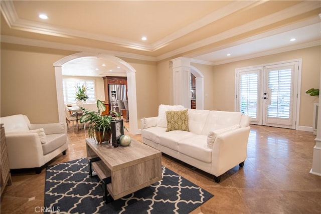 living room with arched walkways, recessed lighting, and a raised ceiling