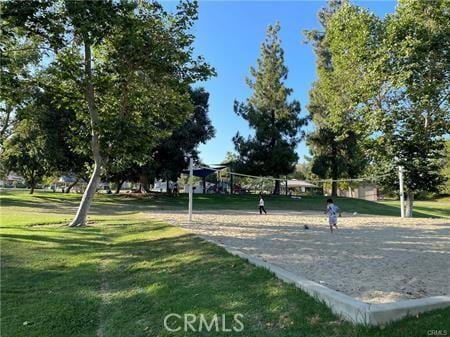 surrounding community with a lawn and volleyball court